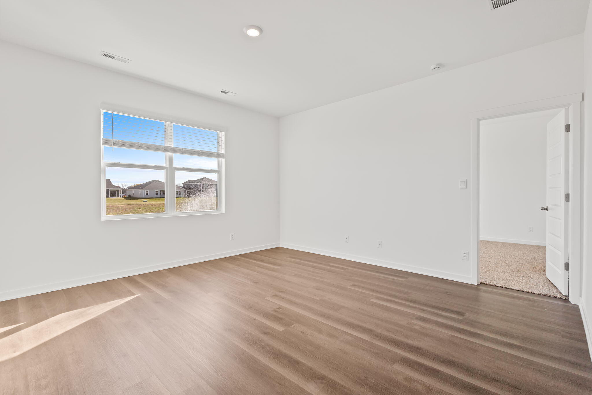 10657 Blaine Street Crown Point, IN 46307 - Photo 11 of 24 an empty room with wooden floor and window