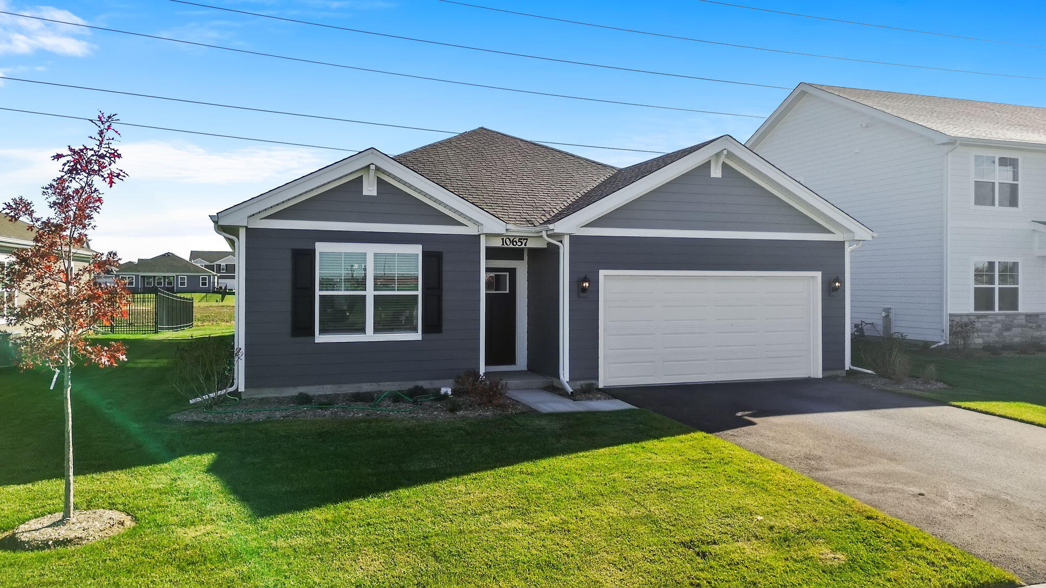 10657 Blaine Street Crown Point, IN 46307 - Photo 2 of 24 a front view of a house with a yard and garage
