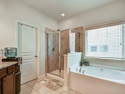 a spacious bathroom with a granite countertop tub shower and a sink
