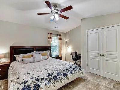 4645 Cold Spring Court Cumming, GA 30041 - Photo 18 of 23 a bedroom with a large bed and a chandelier