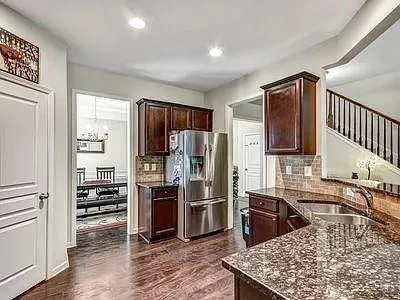 a kitchen with stainless steel appliances granite countertop a refrigerator stove and oven