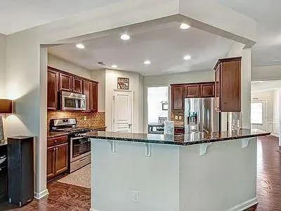 a kitchen with stainless steel appliances granite countertop a sink and a refrigerator