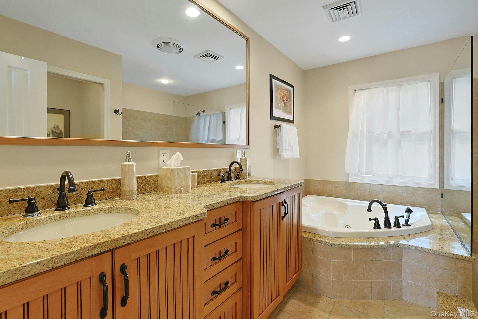 11 Lakeside Road Mahopac, NY 10541 - Photo 22 of 48 Unwind in the gorgeous en suite primary bathroom, featuring a double vanity and a relaxing Jacuzzi tub—the perfect place to end the day.