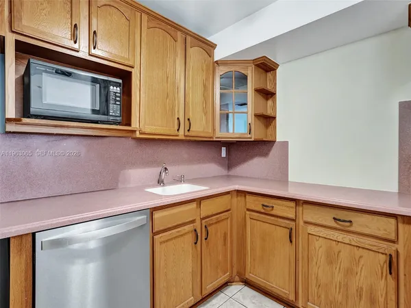 a kitchen with stainless steel appliances granite countertop a sink dishwasher a microwave oven and cabinets with wooden floor
