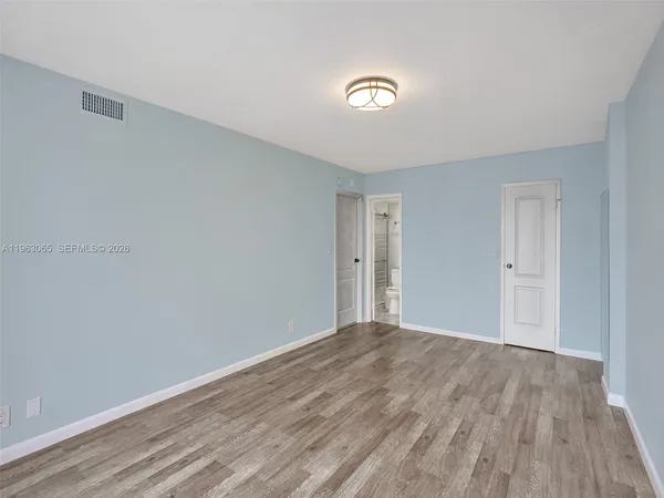 a view of an empty room with wooden floor