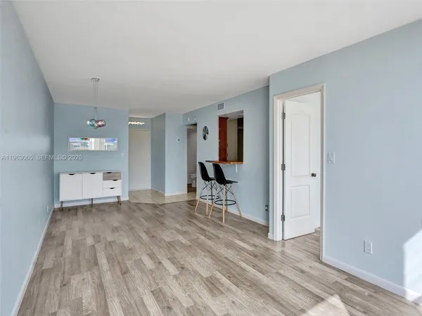 a view of a livingroom with wooden floor and a cabinet