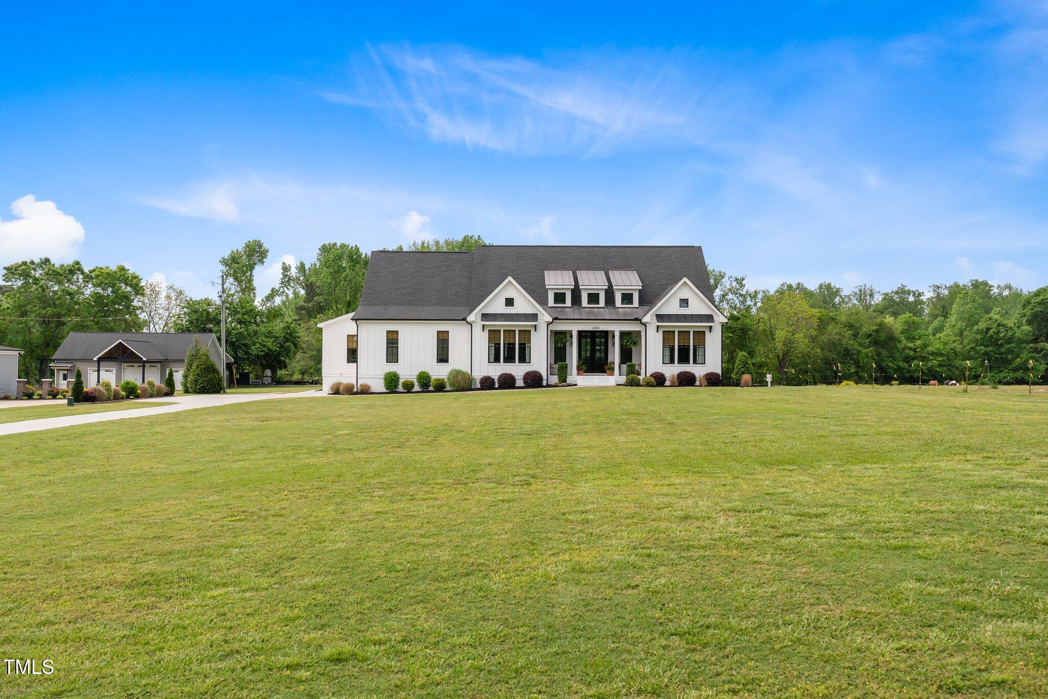 2408 Eddie Howard Road Willow Spring, NC 27592 - Photo 56 of 69 a front view of a house with a garden