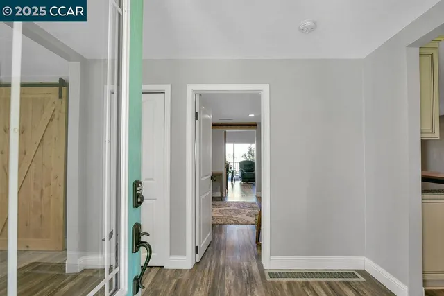 a room with wooden floor table and chairs