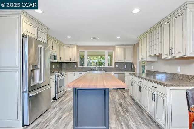 a kitchen with stainless steel appliances granite countertop a stove a sink and a microwave