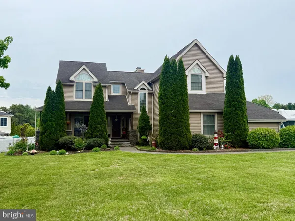 a front view of a house with a yard and trees