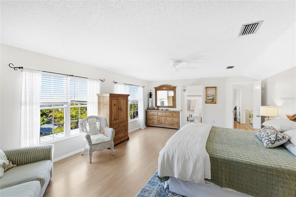 212 85th Street Holmes Beach, FL 34217 - Photo 14 of 45 a spacious bedroom with a bed couch and a large window