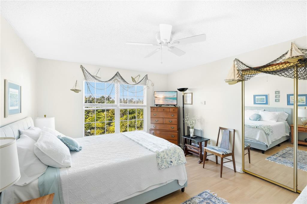 212 85th Street Holmes Beach, FL 34217 - Photo 17 of 45 a bedroom with a bed mirror and window