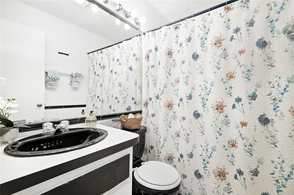 212 85th Street Holmes Beach, FL 34217 - Photo 27 of 45 a bathroom with a sink a toilet and shower curtain