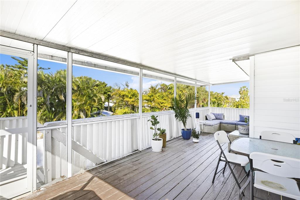 212 85th Street Holmes Beach, FL 34217 - Photo 29 of 45 a view of a balcony with chairs and wooden floor