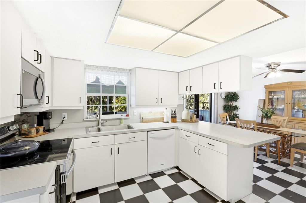 212 85th Street Holmes Beach, FL 34217 - Photo 8 of 45 a kitchen with a sink a stove and cabinets