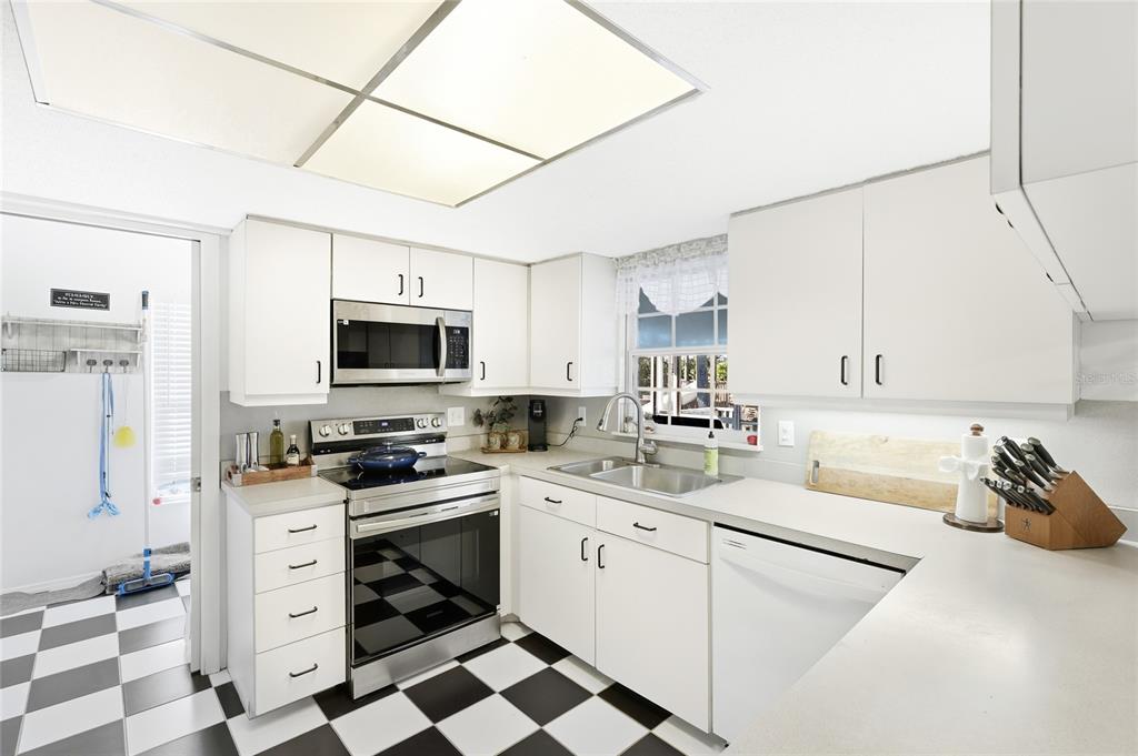 212 85th Street Holmes Beach, FL 34217 - Photo 9 of 45 a kitchen with stainless steel appliances a stove microwave and cabinets