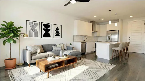 a living room with furniture and kitchen view