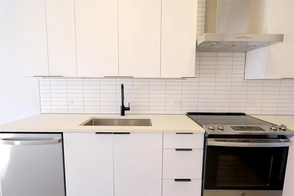 a kitchen with stainless steel appliances granite countertop a sink stove and white cabinets