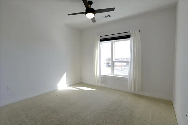 en empty room with windows and fan