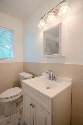 a bathroom with a sink mirror and toilet