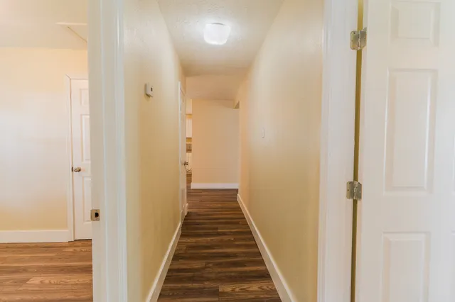 a view of a hallway with wooden floor and staircase
