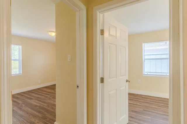 a view of a hallway with wooden floor and closet area
