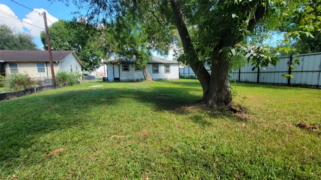 a front view of a house with yard and tree