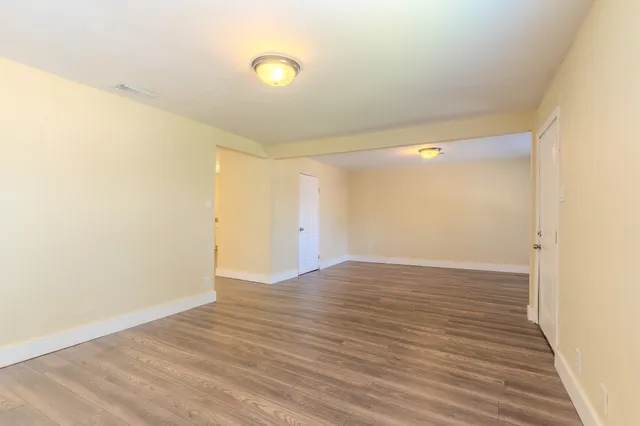 a view of an empty room with wooden floor