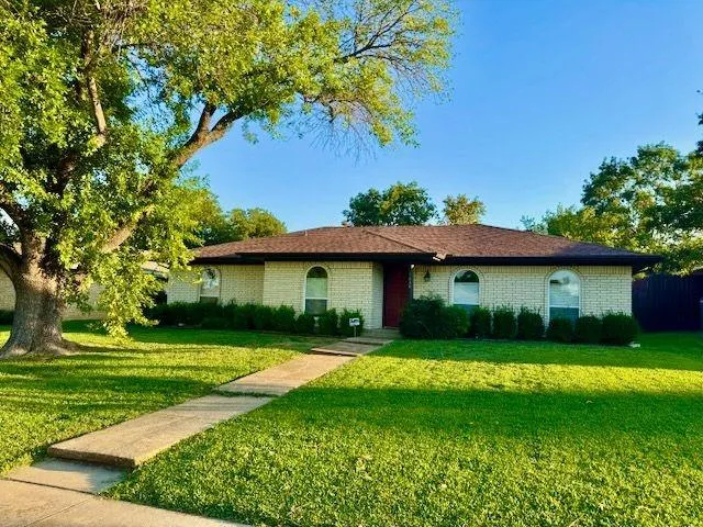 a view of a house with a yard and a tree