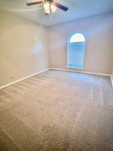 a view of an empty room with a chandelier fan