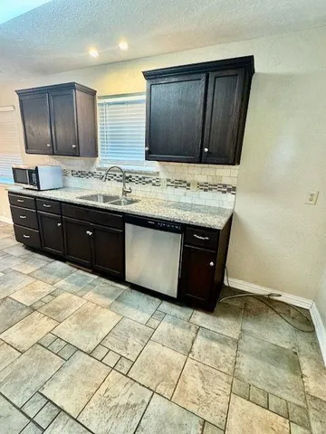 a view of kitchen with granite countertop cabinets and sink
