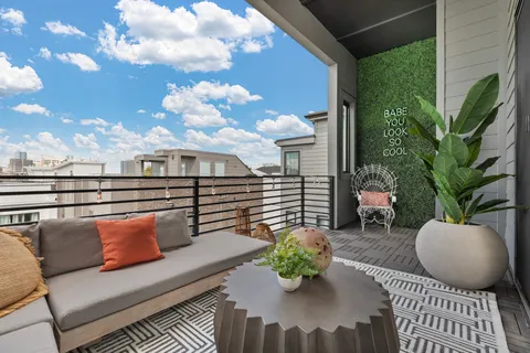 a balcony with furniture and a potted plant