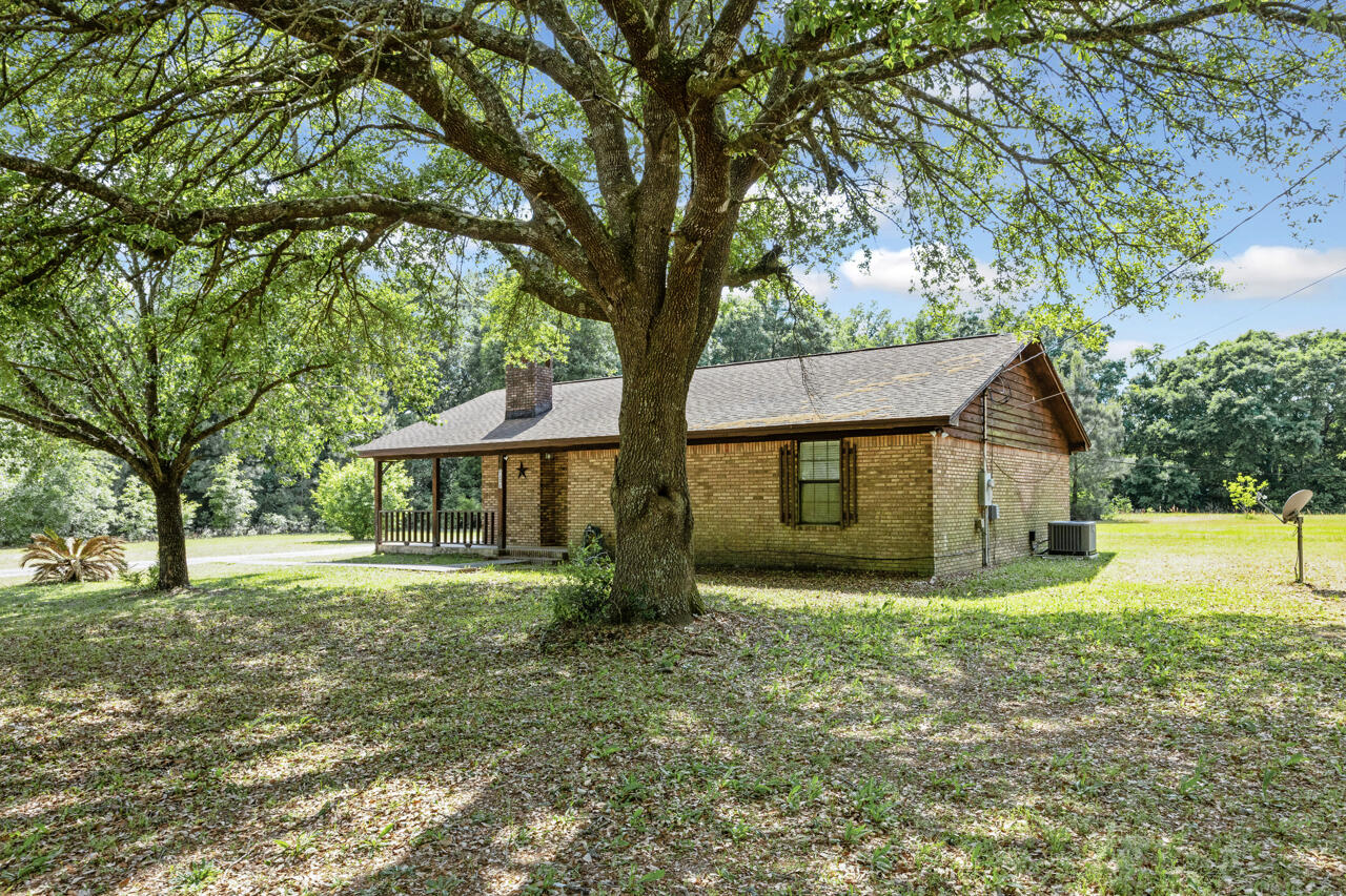 7151 Wallace Drive Pace, FL 32571 - Photo 2 of 40 a front view of a house with a yard and trees
