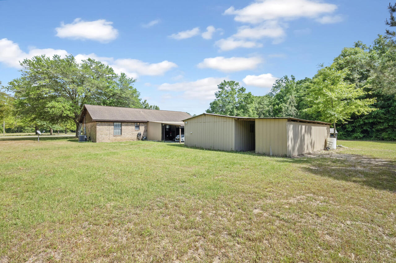 7151 Wallace Drive Pace, FL 32571 - Photo 30 of 40 a front view of house with yard and trees in the background