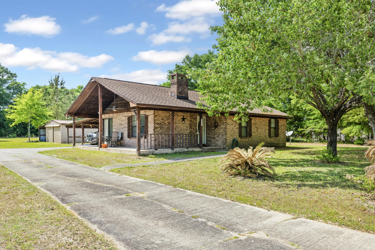 7151 Wallace Drive Pace, FL 32571 - Photo 3 of 40 a front view of a house with a yard table and chairs