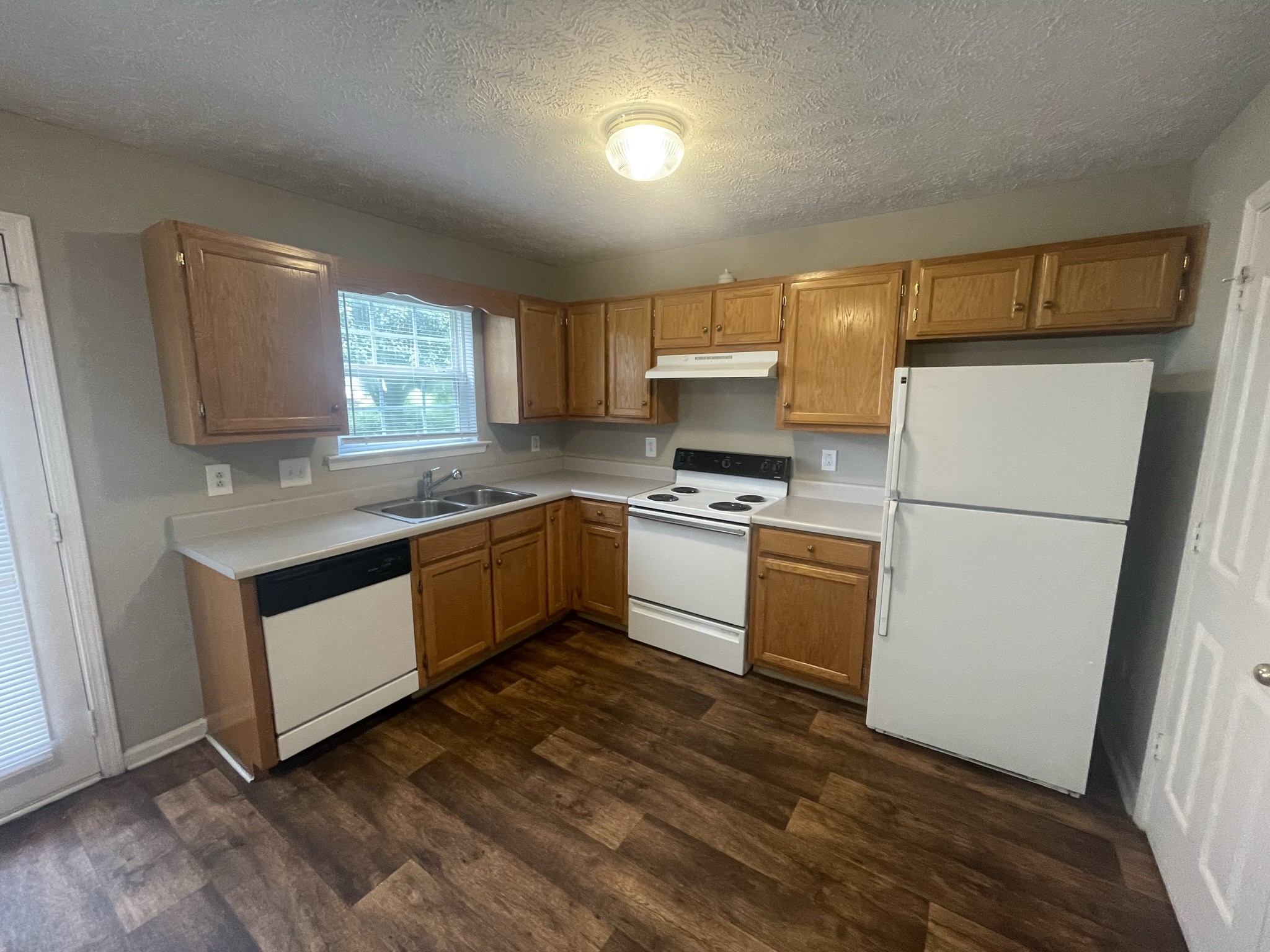 2328 Willowbrook Drive, Unit C Murfreesboro, TN 37130 - Photo 6 of 13 a kitchen with granite countertop a refrigerator a sink dishwasher and a stove with wooden floor