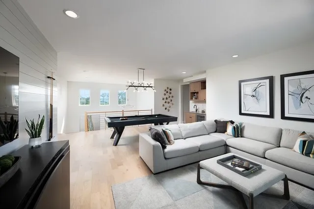 a living room with furniture and a large mirror next to a window