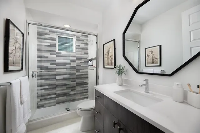 a bathroom with a sink a toilet and shower