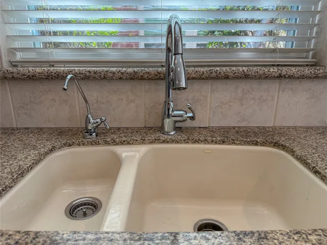 a stove top oven sitting inside of a kitchen with granite countertop wooden cabinets