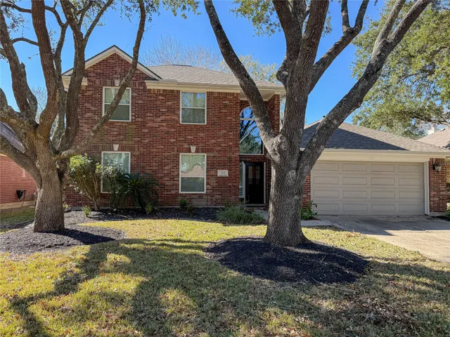 a view of a house with large tree and a yard