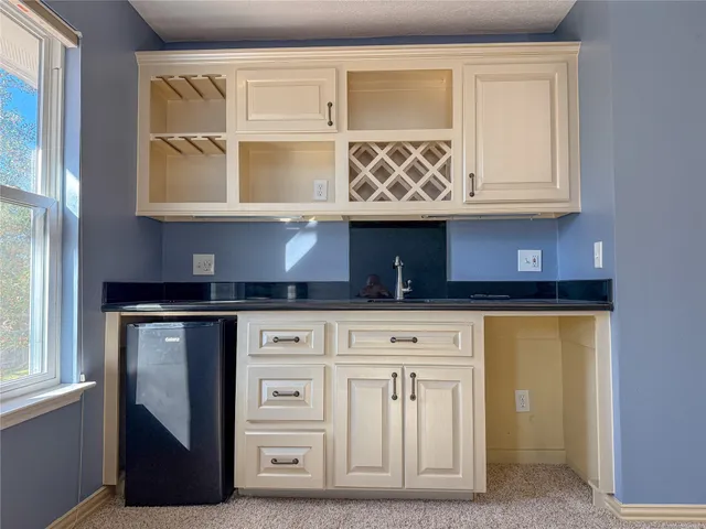 a view of an empty room with window and cabinet