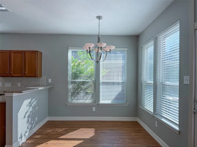 a view of a room with window wooden floor and chandelier