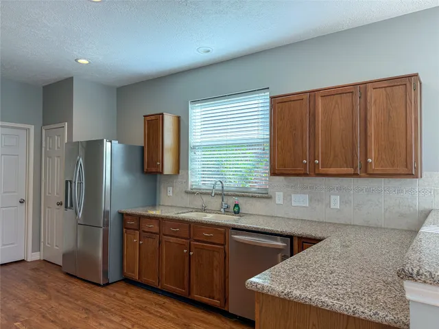 a kitchen with stainless steel appliances granite countertop wooden cabinets a sink and dishwasher