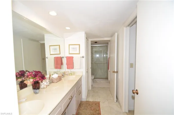 a bathroom with a sink mirror and shower
