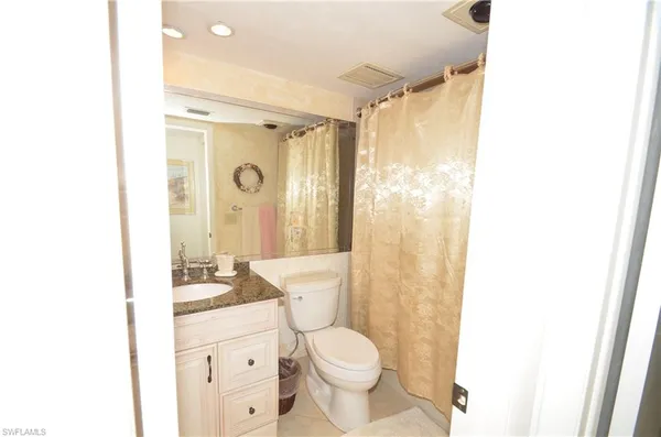 a bathroom with a granite countertop sink toilet and shower
