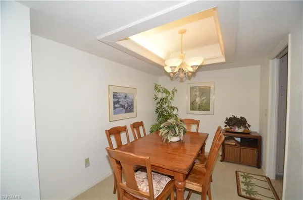 a view of a dining room with furniture and a chandelier