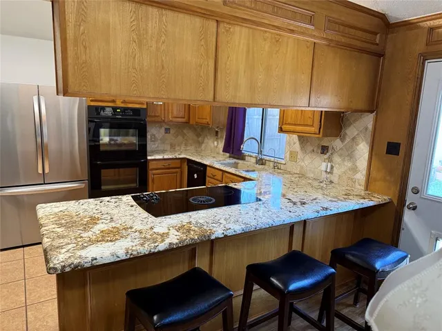 a kitchen with granite countertop a sink and a stove