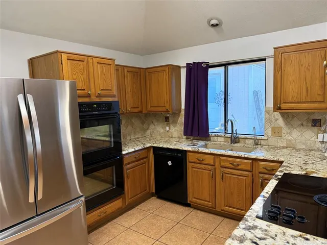 a kitchen with stainless steel appliances granite countertop a refrigerator and a sink