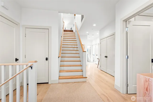 a view of a hallway with entryway wooden floor and front door