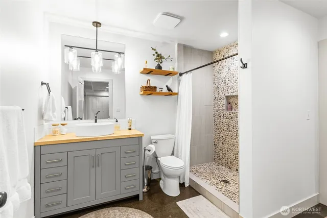 a bathroom with a sink a toilet and shower